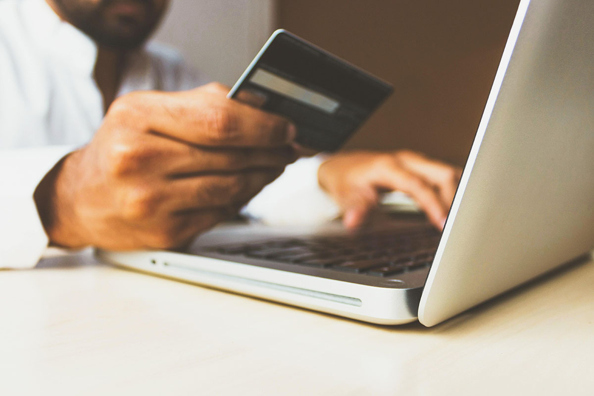 Businessman with credit card on laptop